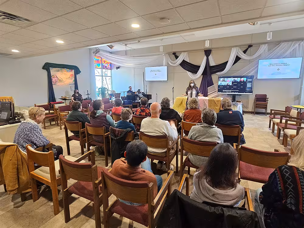 Living Table UCC in Sunday worship — a diverse group gathered in prayer and community